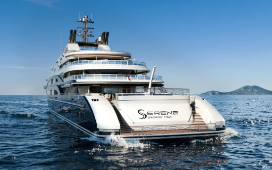 A large luxury yacht named serene cruising on blue water